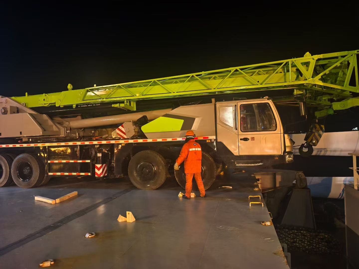 Port facility with large cargo ship and cranes loading containers, industrial setting, daylight conditions